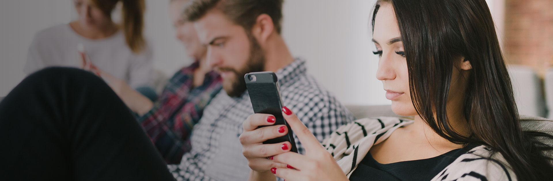 Woman with her friends using mobile phone 