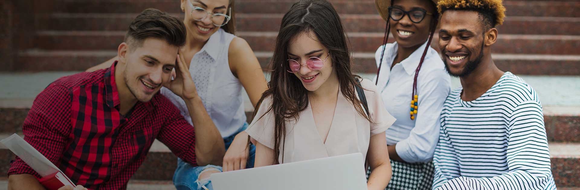 Woman with laptop showing something to her friends