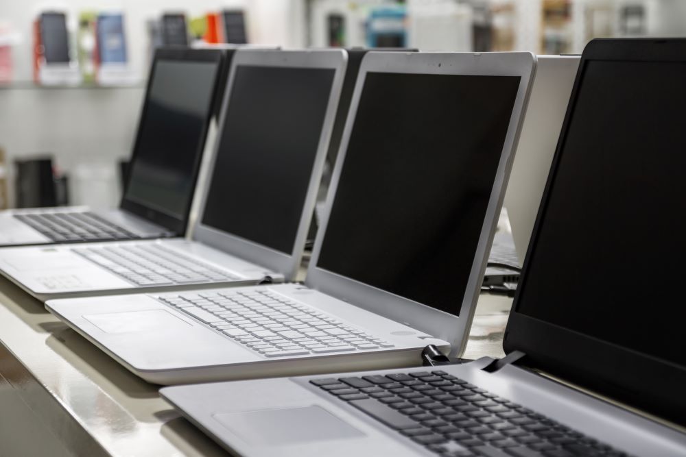 A row of used laptops getting prepped for a laptop trade in.