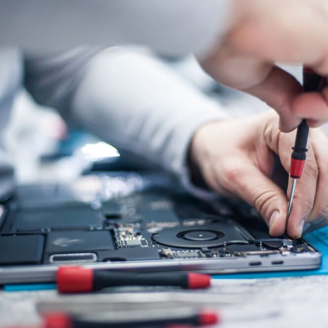 AppleComputerRepairCC A professional computer repair service member repairing an apple computer.