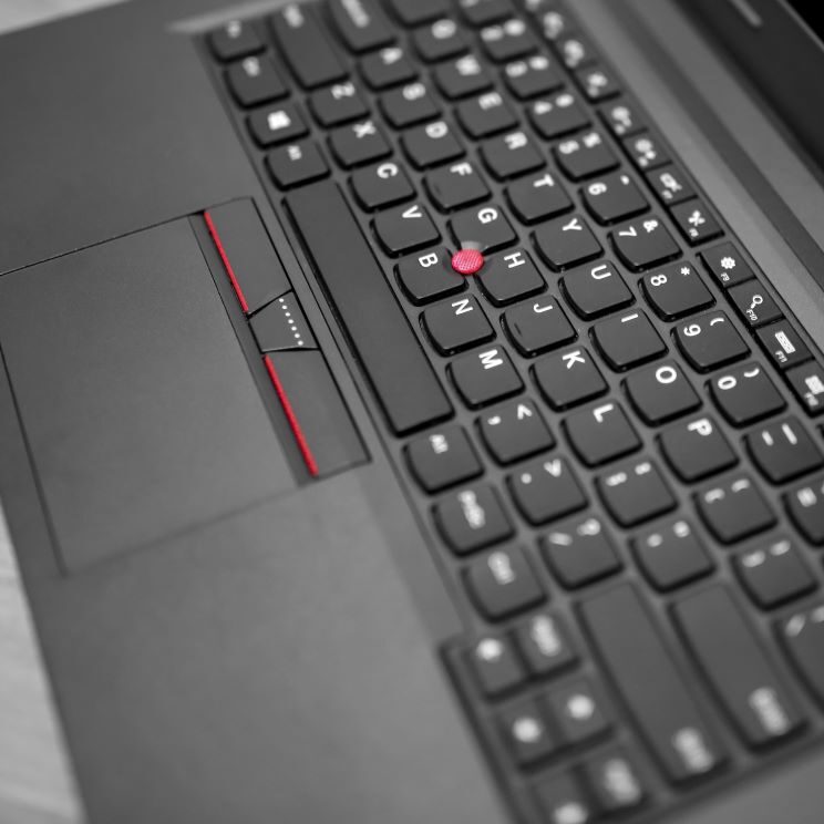 A closeup of a Lenovo Laptop on a desk.