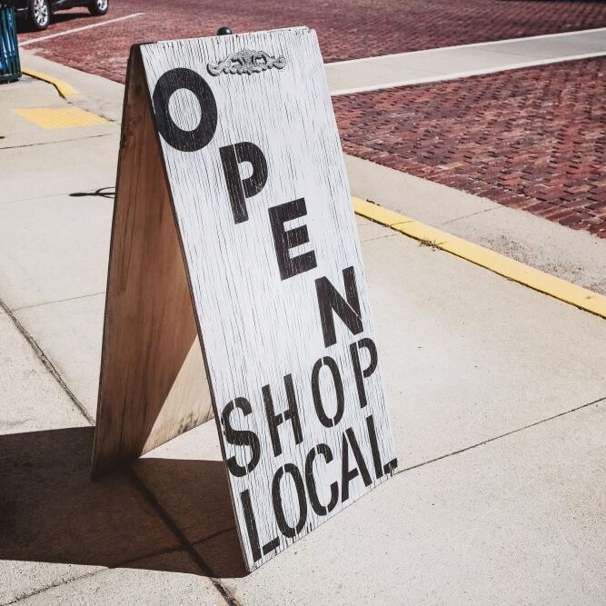 A "shop local" sign outside of a small local business.