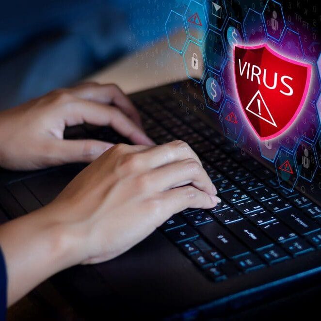 VirusAttackCaliforniaComp A woman working on the computer with a virus notification pop up on the screen.