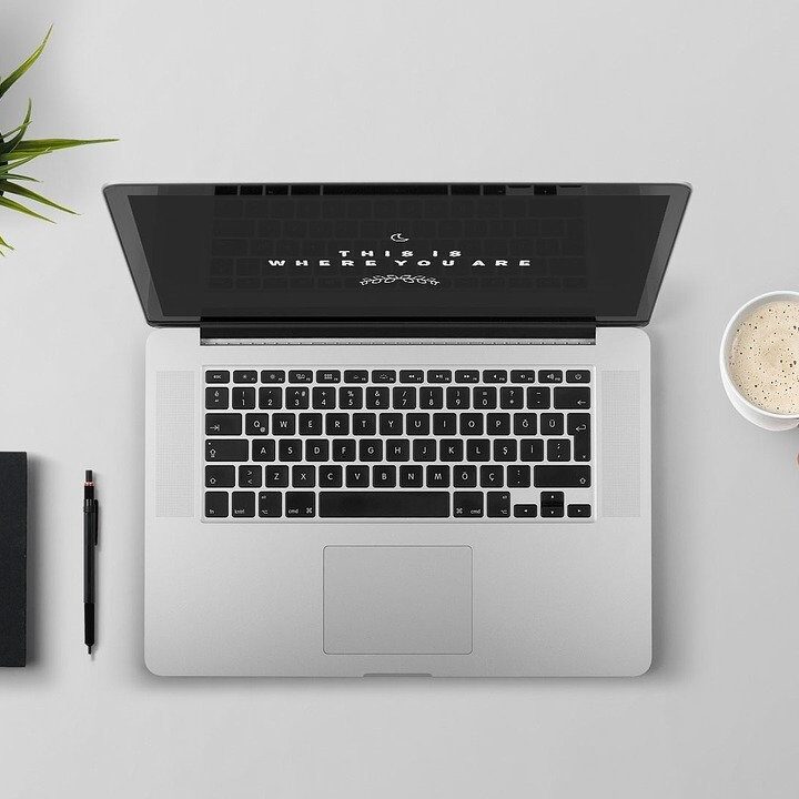 Laptop with Person Holding Coffee Cup